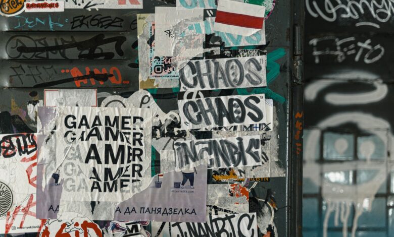 Vibrant urban scene of graffiti and layered posters on a city wall, capturing street art culture.