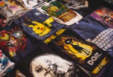 A vibrant assortment of graphic t-shirts featuring popular characters displayed in a market setting.