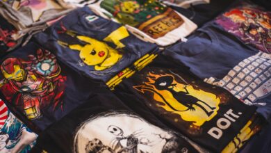 A vibrant assortment of graphic t-shirts featuring popular characters displayed in a market setting.
