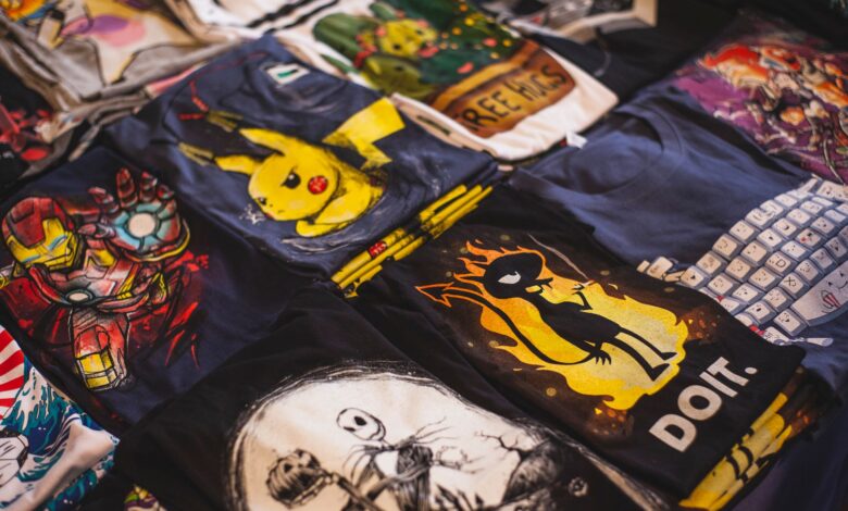 A vibrant assortment of graphic t-shirts featuring popular characters displayed in a market setting.