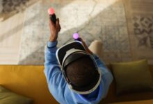 A person wearing virtual reality glasses and using controllers, viewed from above, indoors.