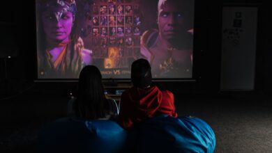Two friends enjoying a video game session on a projector screen, immersed in gameplay.