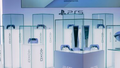 PlayStation 5 consoles and accessories on display in a sleek, futuristic showroom.