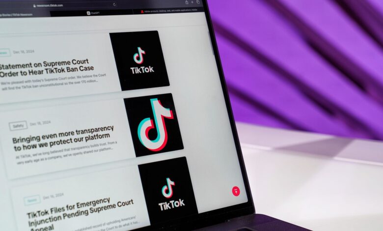 Close-up of laptop screen showing TikTok news articles with a purple background.