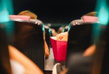 Group enjoying popcorn in a contemporary cinema setting, enhancing the movie experience.