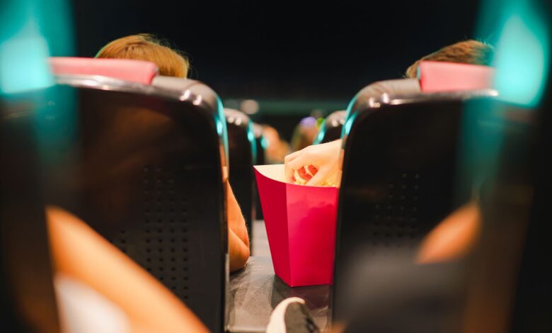 Group enjoying popcorn in a contemporary cinema setting, enhancing the movie experience.