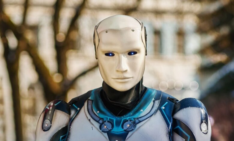 Close-up of a humanoid robot with a futuristic design posing outdoors.