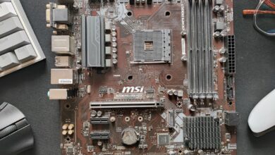 Close-up photo of an MSI B450M Pro-Vdh Plus motherboard on a desk.