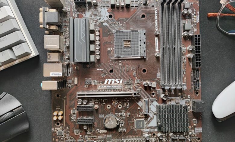 Close-up photo of an MSI B450M Pro-Vdh Plus motherboard on a desk.