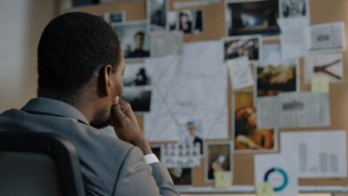 A detective deep in thought, analyzing a crime investigation board filled with photos and notes.