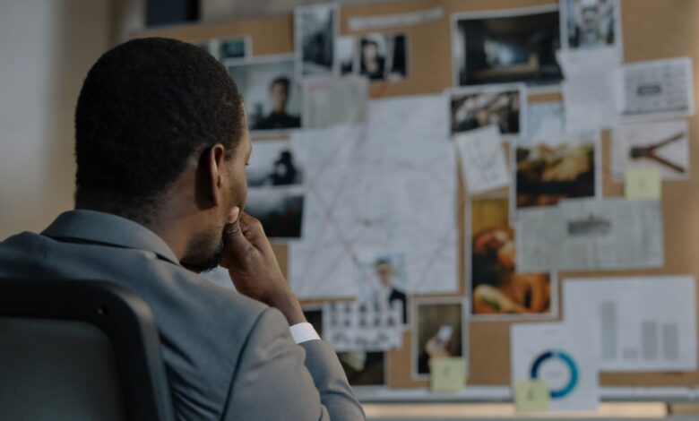 A detective deep in thought, analyzing a crime investigation board filled with photos and notes.