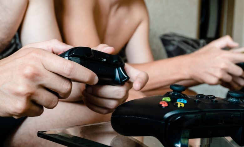 Close-up of adults playing video games with joysticks. Intense multiplayer gaming session.