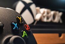 Detailed view of Xbox gaming controller with vibrant buttons displayed indoors.