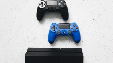 Two game controllers placed on a white surface above a gaming console.