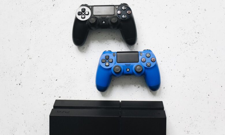 Two game controllers placed on a white surface above a gaming console.