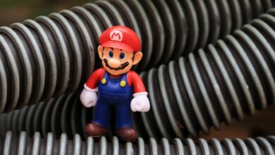 Close-up of a Super Mario toy figure standing among coiled plastic tubes.