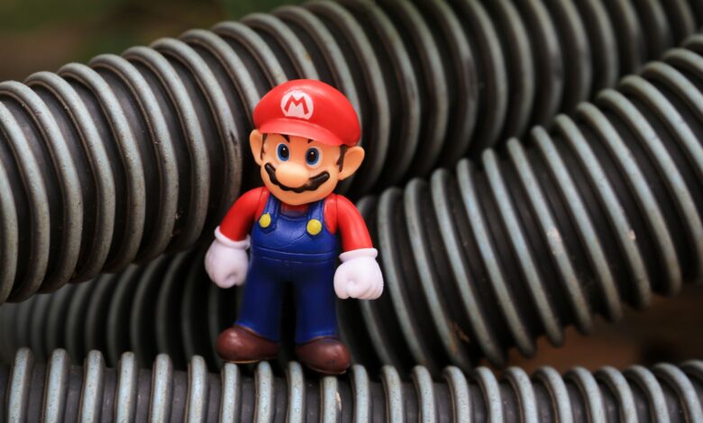 Close-up of a Super Mario toy figure standing among coiled plastic tubes.