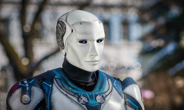 Close-up of a futuristic humanoid robot with metallic armor and blue LED eyes.