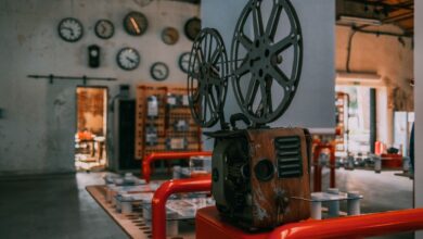 Rustic vintage film projector in an industrial-themed room with wall clocks.