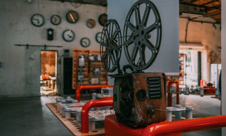 Rustic vintage film projector in an industrial-themed room with wall clocks.