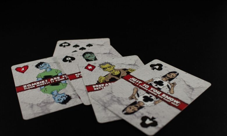 A dramatic still life of zombie-themed playing cards on a black background creates a spooky ambiance.