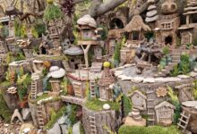 Charming rustic fairy village in the woods with tiny houses and ladders.