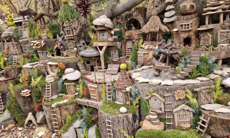 Charming rustic fairy village in the woods with tiny houses and ladders.