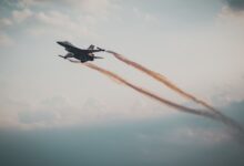 Dynamic capture of a military fighter jet soaring through a cloudy sky.