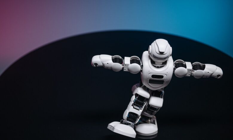 A futuristic white robot toy performing on a sleek dark surface.