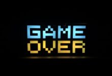 Illuminated pixel art 'Game Over' sign with vibrant colors against a black background.