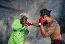 Intense moment of two cosplayers engaged in a dramatic fighting scene.