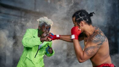Intense moment of two cosplayers engaged in a dramatic fighting scene.