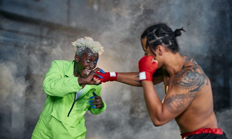 Intense moment of two cosplayers engaged in a dramatic fighting scene.
