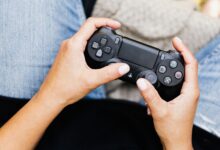 Person holding a video game controller, ideal for leisure and gaming themes.