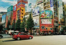 Street view of Akihabara, Tokyo with colorful billboards and bustling activity.