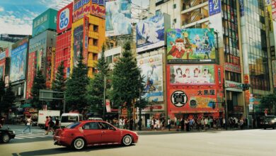 Street view of Akihabara, Tokyo with colorful billboards and bustling activity.