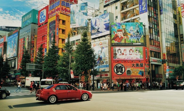Street view of Akihabara, Tokyo with colorful billboards and bustling activity.