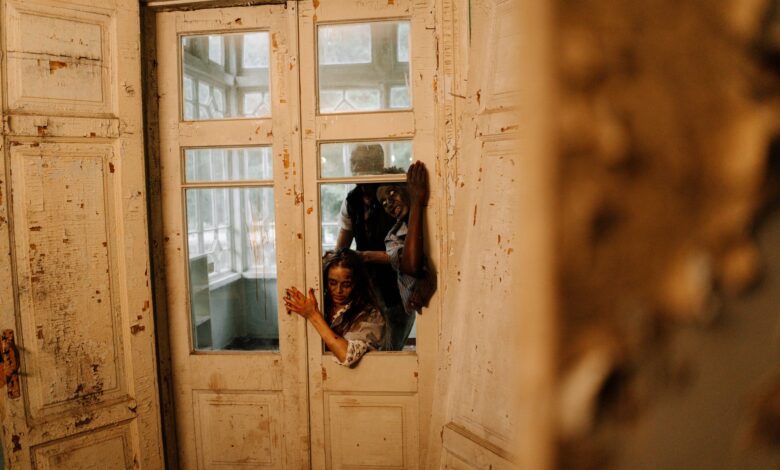 Spooky horror scene with zombies breaking through an old wooden door, perfect for Halloween themes.