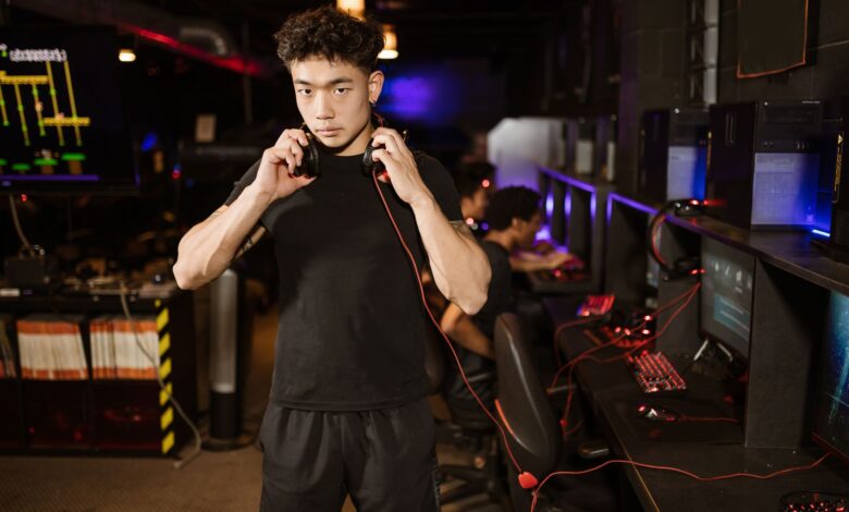 A serious young man in a gaming lounge with headphones, embodying the modern e-sports culture.