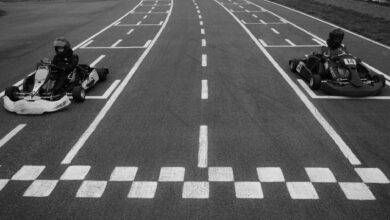 Two go-karts at the starting line on a racetrack, ready for a competitive race.