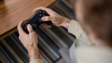 Detailed view of a person holding a gaming controller indoors, emphasizing the gameplay action.