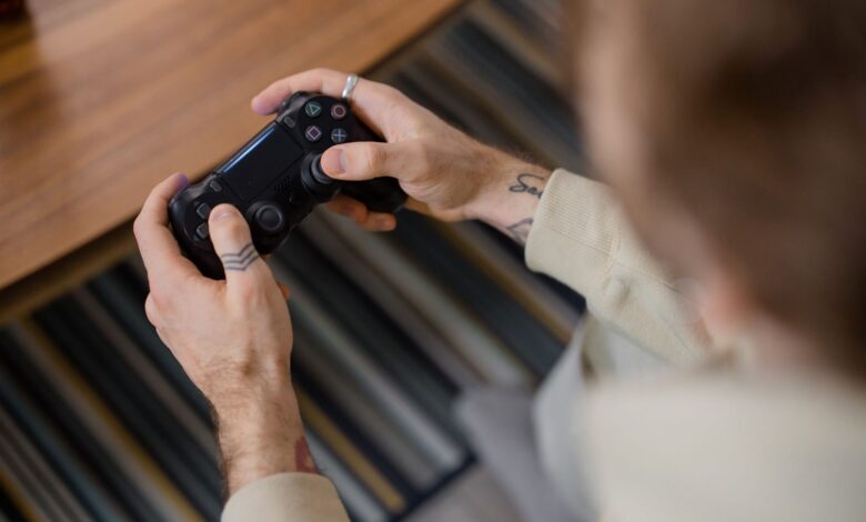 Detailed view of a person holding a gaming controller indoors, emphasizing the gameplay action.