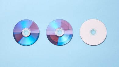 Three classic compact discs with a nostalgic tone on a pastel blue background.