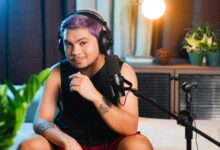 Musician sitting indoors with headphones and microphone, ready to record a podcast.