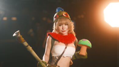 Female cosplayer in vibrant costume holding a toy prop, showcasing charismatic character portrayal.