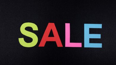Multicolor letters spelling SALE on a textured black surface, perfect for promotional use.