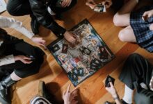 Aerial view of friends enjoying a board game on wooden floor.