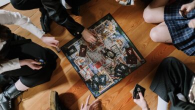 Aerial view of friends enjoying a board game on wooden floor.