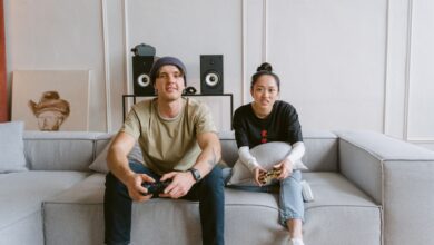 Man and woman playing video games on a couch, conveying a relaxed and fun atmosphere.