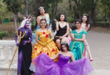 A cheerful group of women in fantasy costumes posing outdoors, exuding vibrant colors and playful energy.